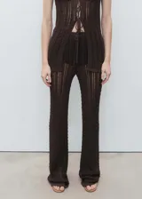 Pantalón de tiro medio confeccionado en tejido de punto calado, con diseño recto y largo. Cuenta con cintura elástica y forro interior.