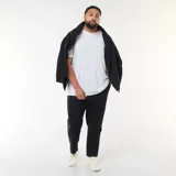 Conjunto deportivo de felpa color negro, compuesto por un buzo canguro con cierre y capucha y un pantalón jogger a juego.
