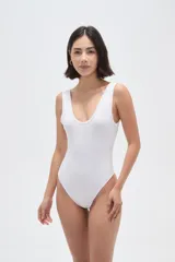 Body de poliamida al cuerpo con breteles anchos, cuello profundo y cierre con broches en la parte inferior.