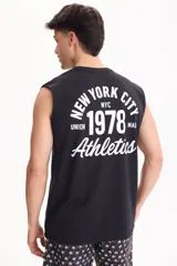 Musculosa negra de algodón, con diseño sin mangas y estampado gráfico blanco en la espalda con texto y números deportivos estilo universitario.