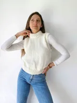 Chaleco tejido a mano color beige con cuello alto y sisas amplias.