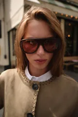 Chaqueta color tostado con efecto ante, cuello redondo y manga larga. Presenta detalles de acabados trenzados en el cuello, el cierre frontal, los puños y el bajo. Cuenta con cierre frontal de botones y bolsillos delanteros de vivo.