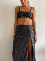 Pollera larga negra cubierta de lentejuelas, con tajo lateral alto.