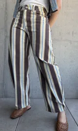 Jean modelo barrel de corte amplio, con diseño de rayas verticales en tonos marrón chocolate, celeste, tostado y blanco.