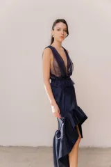 Pollera midi de tafeta con diseño asimétrico, más corta adelante y larga atrás, con volado en el ruedo y corte evasé.