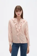 Blusa de viscosa con estampado de cuadros y pequeños puntos, diseño holgado, cuello a la base con volados frontales, cierre de botones y mangas largas con puños.