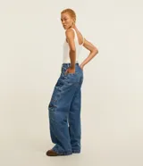 Pantalón estilo años 90 de tiro alto confeccionado en jean, con bolsillos cargo en los laterales y trabillas en la cintura.