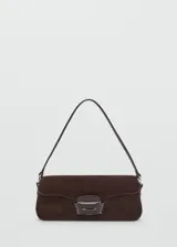 Bolso de hombro tipo baguette confeccionado en piel de serraje color marrón oscuro. Presenta un diseño rectangular con cierre de solapa y detalle metálico frontal. Incluye forro interior y bolsillo interno.