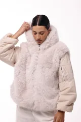 Campera de invierno con frente de piel sintética y capucha integrada, combinada con mangas acolchadas de estilo puffer en color marrón oscuro.