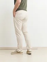 Pantalón largo color beige, de corte recto y estilo casual.