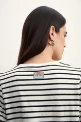 Remera de algodón con estampado de rayas horizontales en color verde claro sobre fondo blanco, con mangas cortas abullonadas y puños lisos.