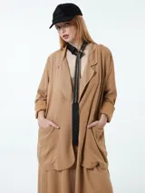 Blazer color marrón claro, de corte holgado, con solapas y bolsillos delanteros.