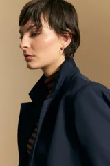 Blazer de corte sastrero con solapas clásicas y estructura definida. Presenta un diseño versátil con silueta ligeramente oversized, ideal para un estilo sofisticado y atemporal.