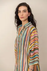 Vestido corto camisero con estampado de rayas multicolores, cuello camisero, mangas tres cuartos y cierre frontal de botones.