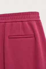 Pantalón jogger relaxed fit color bordó, confeccionado en tejido con algodón e interior forrado en tejido polar. Cuenta con cintura elástica, bolsillos frontales, bolsillos traseros de vivo y detalle de costura frontal en las perneras.