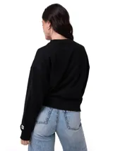 Buzo de cuello redondo color negro, con calce holgado y mangas largas. Presenta un estampado gráfico en el pecho con forma de corazón y la palabra 'Caterpillar', además de una etiqueta con el logo de la marca en el puño izquierdo. Posee puños, cuello y ruedo acanalados.