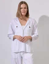 Chaqueta blanca de tencel con cuello con solapa, escote en V y abertura central con broches internos. Tiene corte en la cintura y bolsillos delanteros.