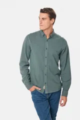 Camisa de manga larga color verde oscuro, con cuello abotonado y logo bordado en el pecho.