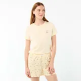 Conjunto de pijama de dos piezas compuesto por una remera de manga corta color amarillo claro con pequeño estampado en el pecho, y un short amarillo con estampado de rayas verticales y cerezas, con elástico en la cintura.