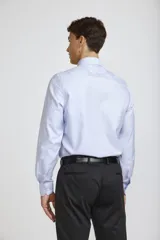 Camisa de vestir blanca de corte clásico, con cuello rígido, cierre frontal de botones y mangas largas con puños abotonados.