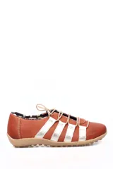 Zapato estilo deportivo casual de cuero color marrón tierra con tiras laterales en tono dorado metalizado. Presenta cierre con cordones elásticos y suela de goma en color beige.