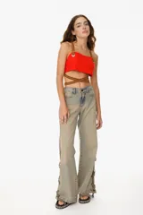 Top rojo ajustable con tiras de cuero sintético marrón en el contorno del pecho y en los breteles. Cuenta con dos ojales metálicos y tiras largas que permiten entrecruzarse en el torso.