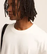 Remera masculina blanca de corte relajado, cuello redondo y manga corta. Confeccionada en malla de algodón 100% sostenible.