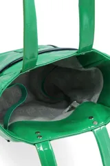 Bolso tipo tote de charol en color verde brillante, con doble asa de mano y detalle de ribetes en contraste. Presenta el nombre de la marca estampado en la parte inferior frontal y remaches metálicos en la base de las asas.