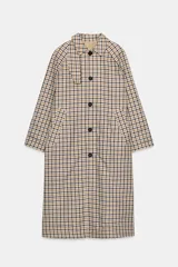 Trench reversible de Zara Woman Collection con diseño de cuadros en tonos beige, negro y tostado. Cuenta con cuello de solapa, cierre frontal con botones oscuros y bolsillos delanteros diagonales.