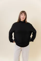 Polera de tejido de punto con textura marcada, cuello alto y diseño oversize con hombros caídos y terminaciones acanaladas.