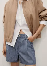 Short de tiro medio confeccionado en tejido de algodón estilo denim con diseño de rayas verticales. Presenta cierre de botón y cremallera, trabillas para cinturón, detalle de pinzas y cuatro bolsillos.