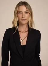 Blazer negro entallado de tela lisa, con solapas de pico, bolsillo frontal incorporado y solapas aplicadas, mangas largas, cierre de botones en la parte delantera y forro incorporado.