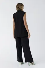 Pantalón negro de vestir de corte palazzo con cintura alta y bolsillos laterales.