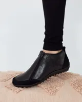 Zapato bajo de cuero negro con puntera redondeada y cierre frontal con cremallera doble.