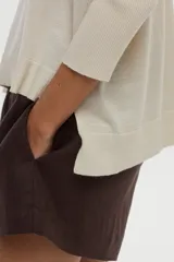 Sweater de punto con escote en V y mangas cortas, confeccionado con hilo metalizado con lurex, de calce cómodo y holgado.