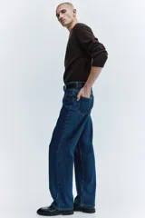 Jean de cinco bolsillos en denim de algodón rígido, con cintura clásica y cierre de botones. Modelo de corte relajado y piernas rectas.