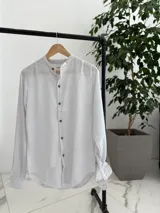 Camisa de lino blanca con finas rayas negras, cuello mao y cierre frontal con botones de madera.