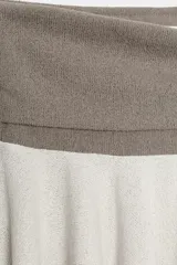 Falda mini de tiro bajo con cintura elástica ancha en color marrón y falda en color beige con bajo asimétrico.