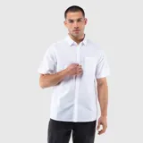 Camisa de manga corta confeccionada en mezcla de lino y algodón, con cuello clásico, cierre frontal de botones y bolsillo en el pecho.