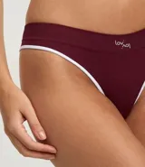 Bombacha tipo bikini de corte clásico, confeccionada en tejido de poliamida texturizado con tecnología seamless. Presenta un diseño liso en color bordó con bordes en contraste color blanco y detalle de logo bordado en el frente.
