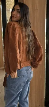 Camisa de manga larga con volumen y puños elásticos, de color marrón oscuro.