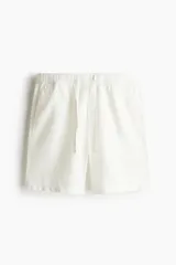 Short de corte relajado confeccionado en tejido liviano de algodón y viscosa, color blanco. Presenta cintura elástica con cordón de ajuste, bolsillos laterales al bies y un bolsillo insertado en la parte posterior.