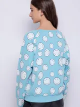 Buzo gris de tela deportiva con estampado de caritas felices rosas, manga larga y cuello redondo.