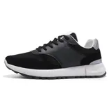Zapatillas deportivas de estilo retro, combinando paneles de malla negra, gamuza negra y cuero sintético negro. Cuentan con cordones negros, forro interior blanco y un cuello acolchado con detalle plateado en el talón. La suela es gruesa y blanca con una banda de rodadura negra.