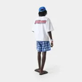 Remera oversized de algodón blanca, de manga corta y cuello redondo, con estampado gráfico multicolor en la espalda.