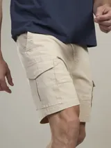 Bermuda cargo de gabardina color beige, con bolsillos laterales con solapa y cierre frontal con botón y cremallera.