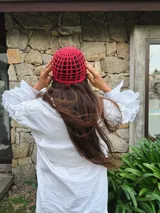 Gorro tipo casquete rojo de crochet con diseño calado.