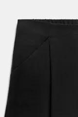 Pantalón tipo culotte de tiro medio, con pierna ancha, bolsillos delanteros y detalle de pinzas. Cuenta con cierre frontal de cremallera y gancho metálico.