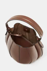Bolso marrón con forma de saca, detalle de pespuntes en el corte y asa de mano. Incluye correa extraíble para usar como bandolera y cartera con bolsillo extraíble. Cierre con botón imantado.