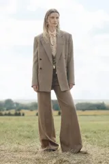 Blazer de lana a cuadros color marrón, con cuello solapa de muescas y manga larga. Tiene bolsillos con solapa en delantero y de vivo en pecho. Cierre frontal cruzado con botones.